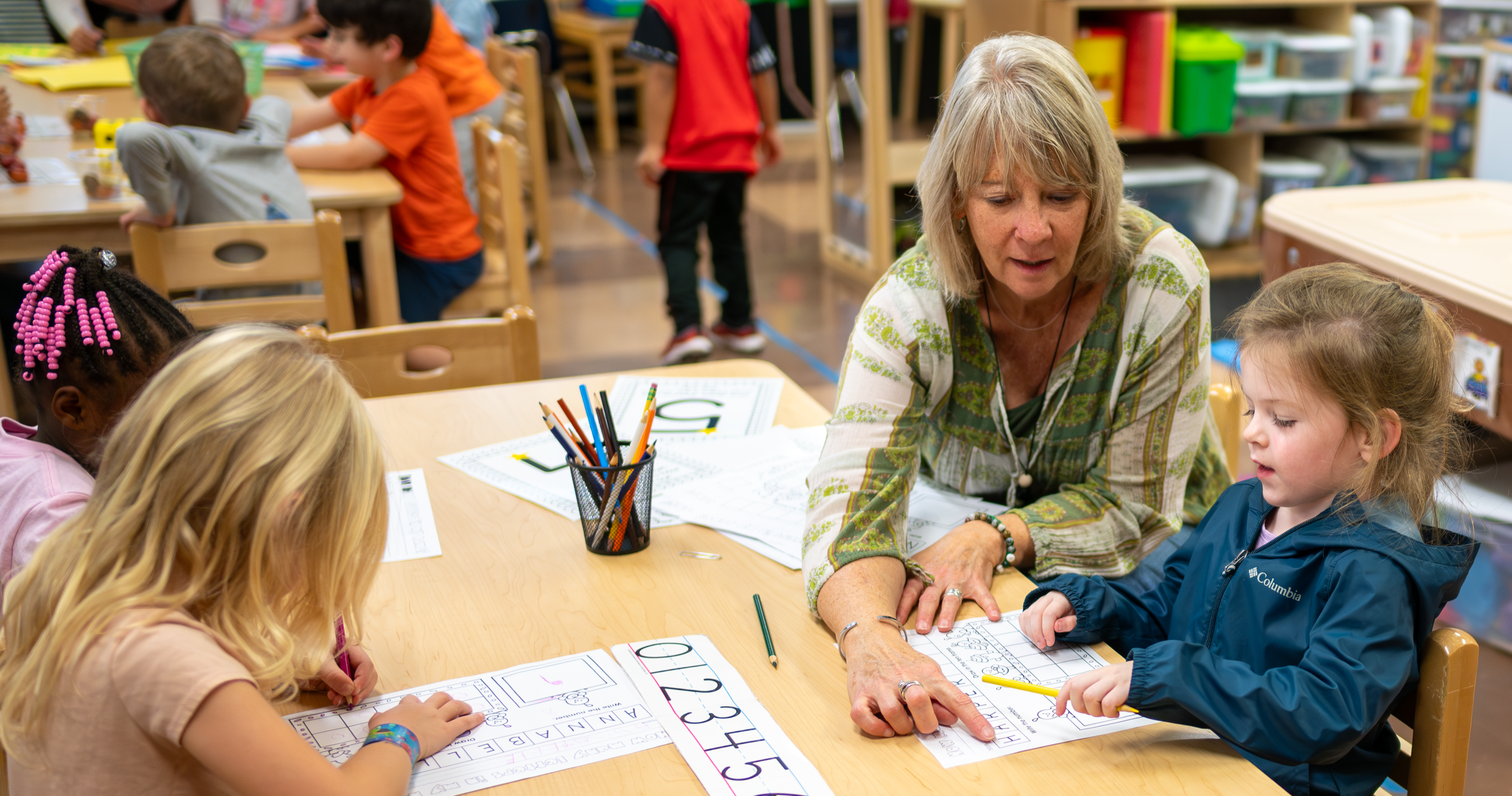 Teacher with students at desk