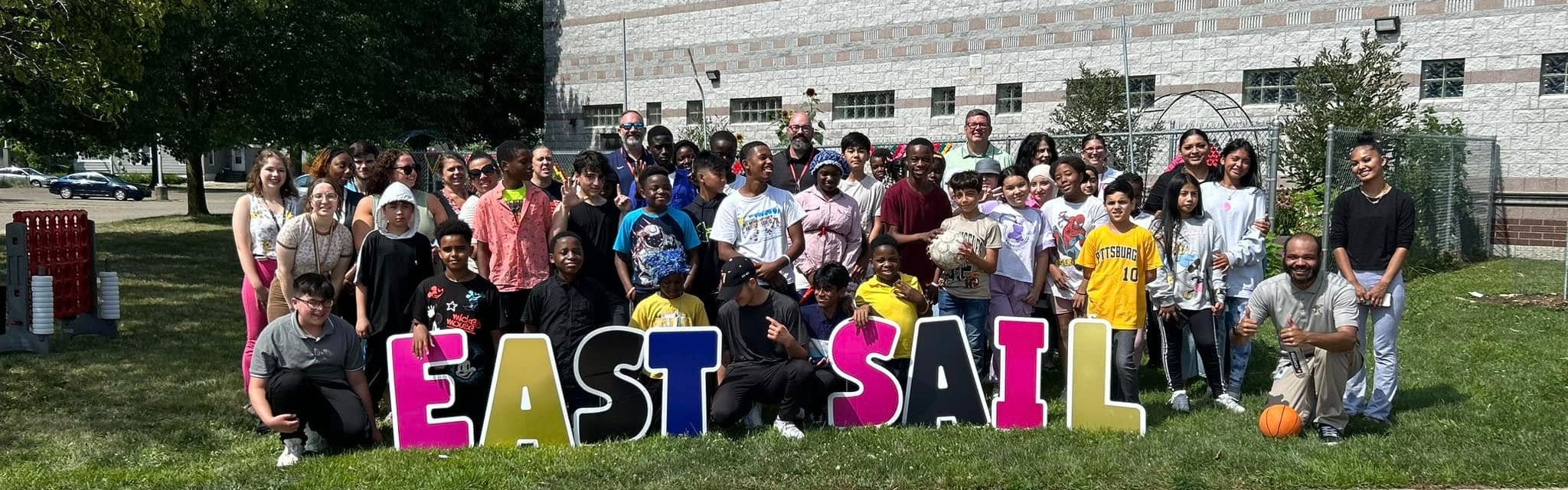 A group of students and adults standing outside smiling. 
