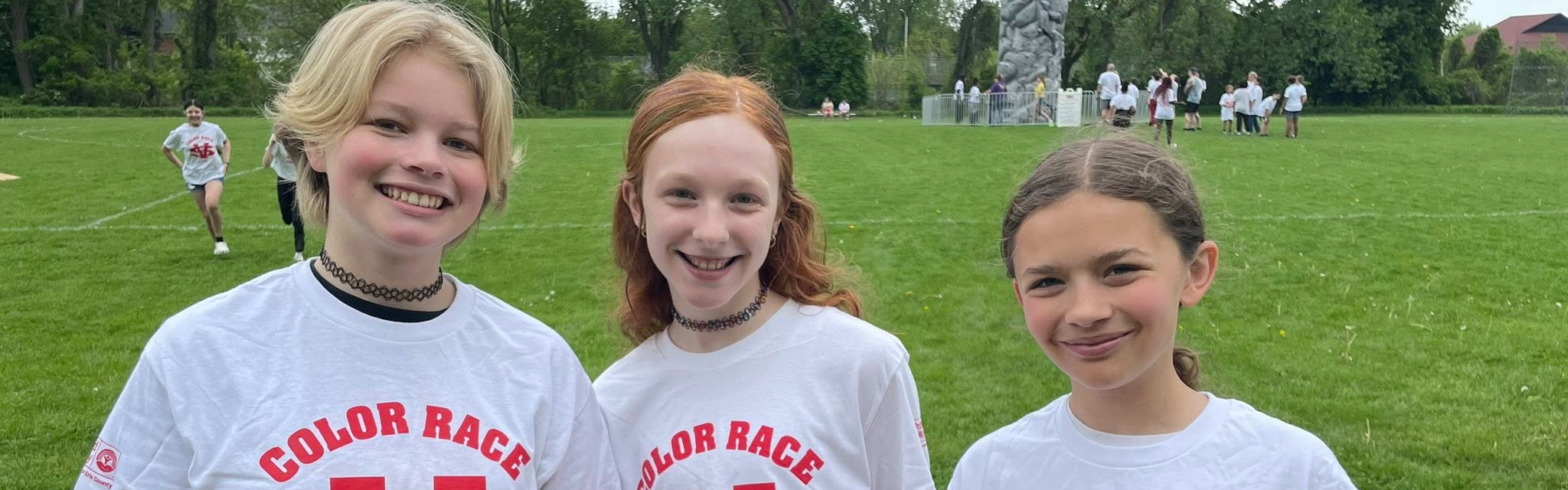 group of students smiling in white shirts.