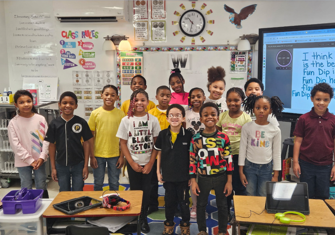 Students smiling in a classroom. 