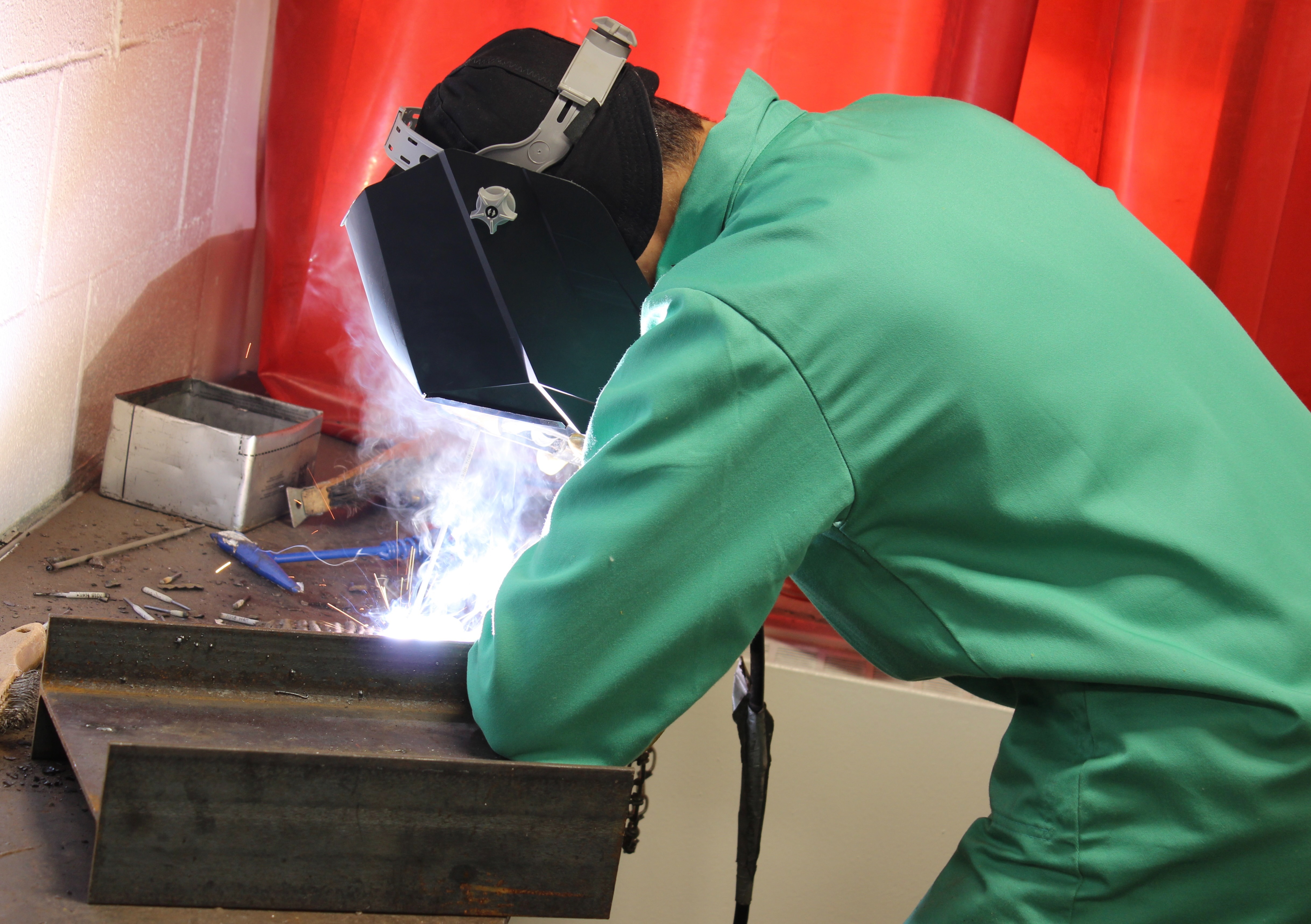 Welding student practices technique in classroom