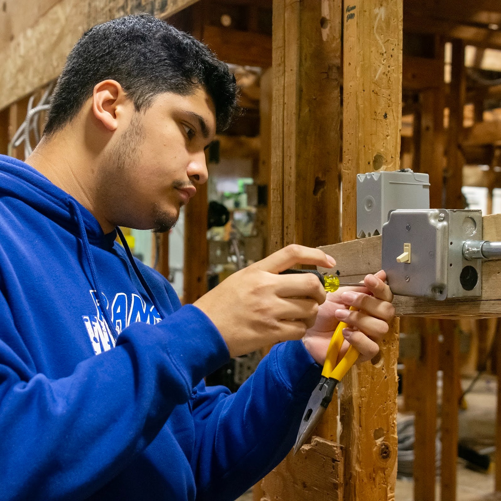 Electrical Construction student wires a switch in a framed-out structure