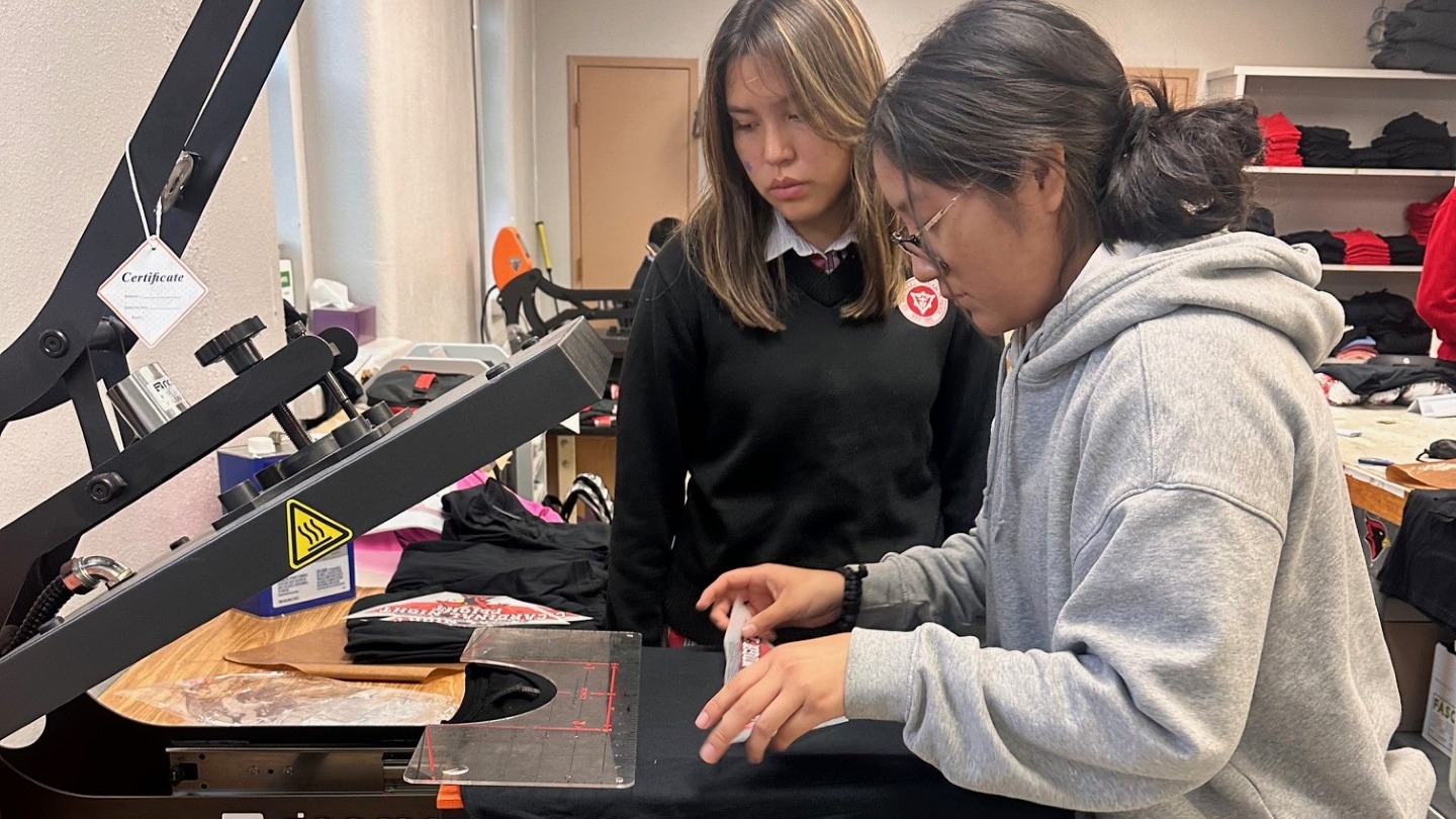 Students pressing image on press machine
