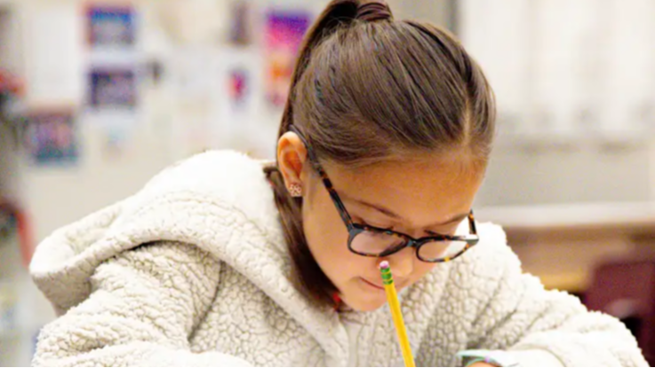 Student writing with a pencil