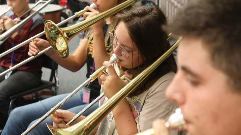 Students playing trombones in a school band class.
