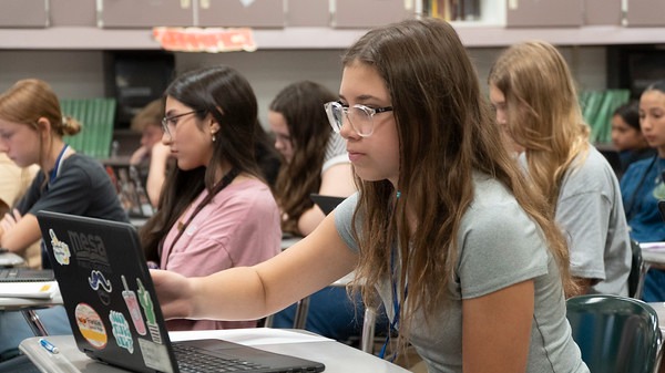 Students working on laptops in a classroom.