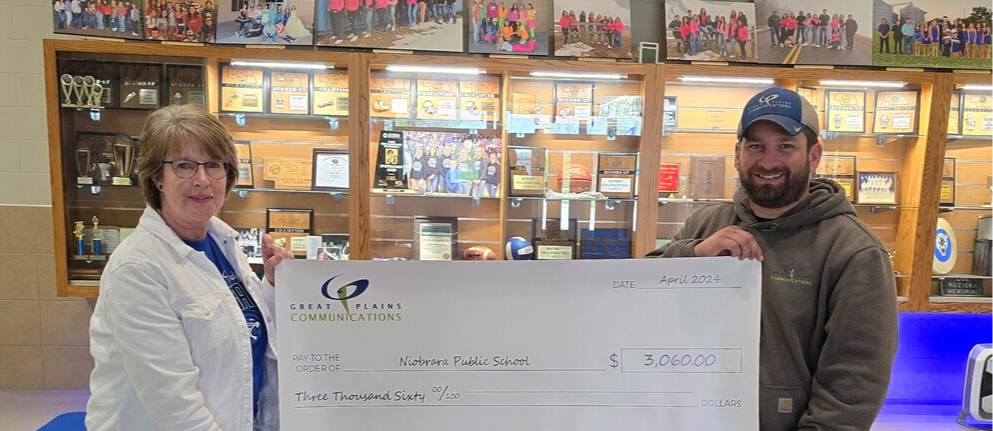 Staff holding check from Great Plains Communications for $3060