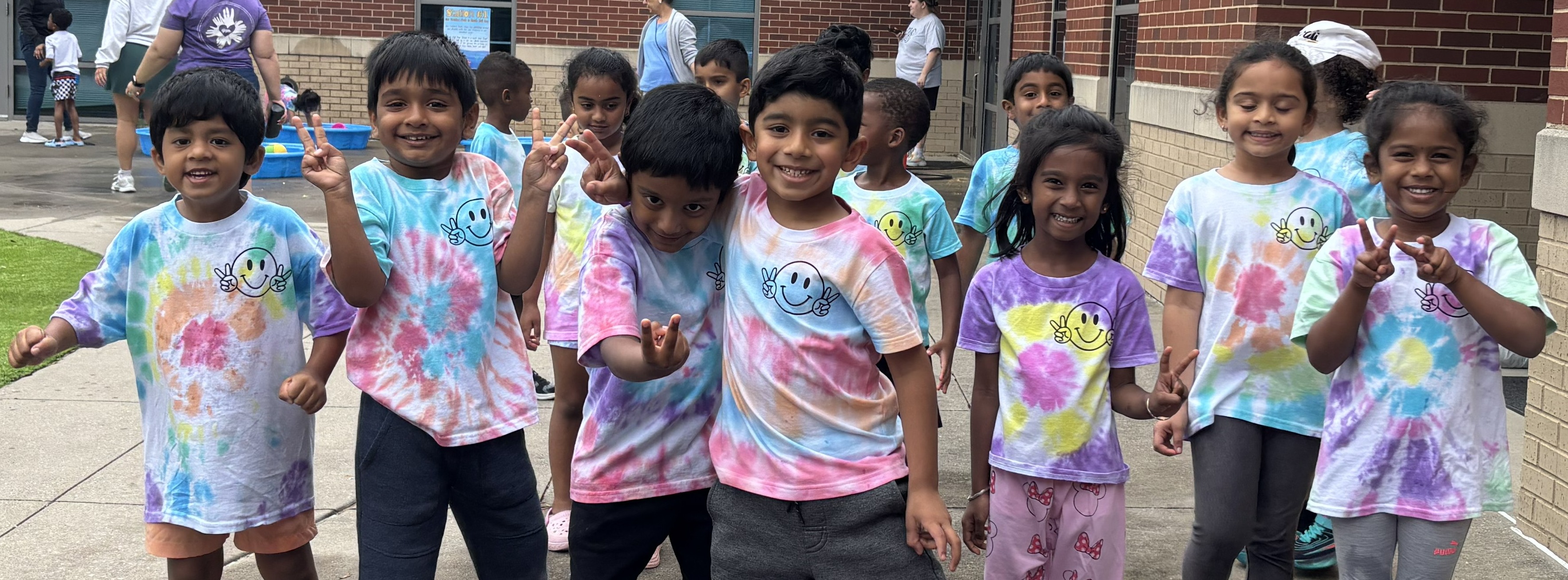 Students in tie dye shirts standing outside at Big Day