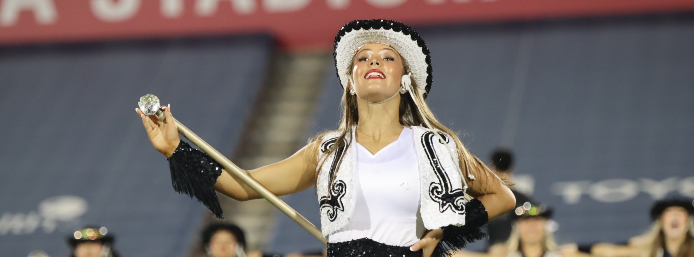 Black Diamonds Drill Team Leader performs at football game. 