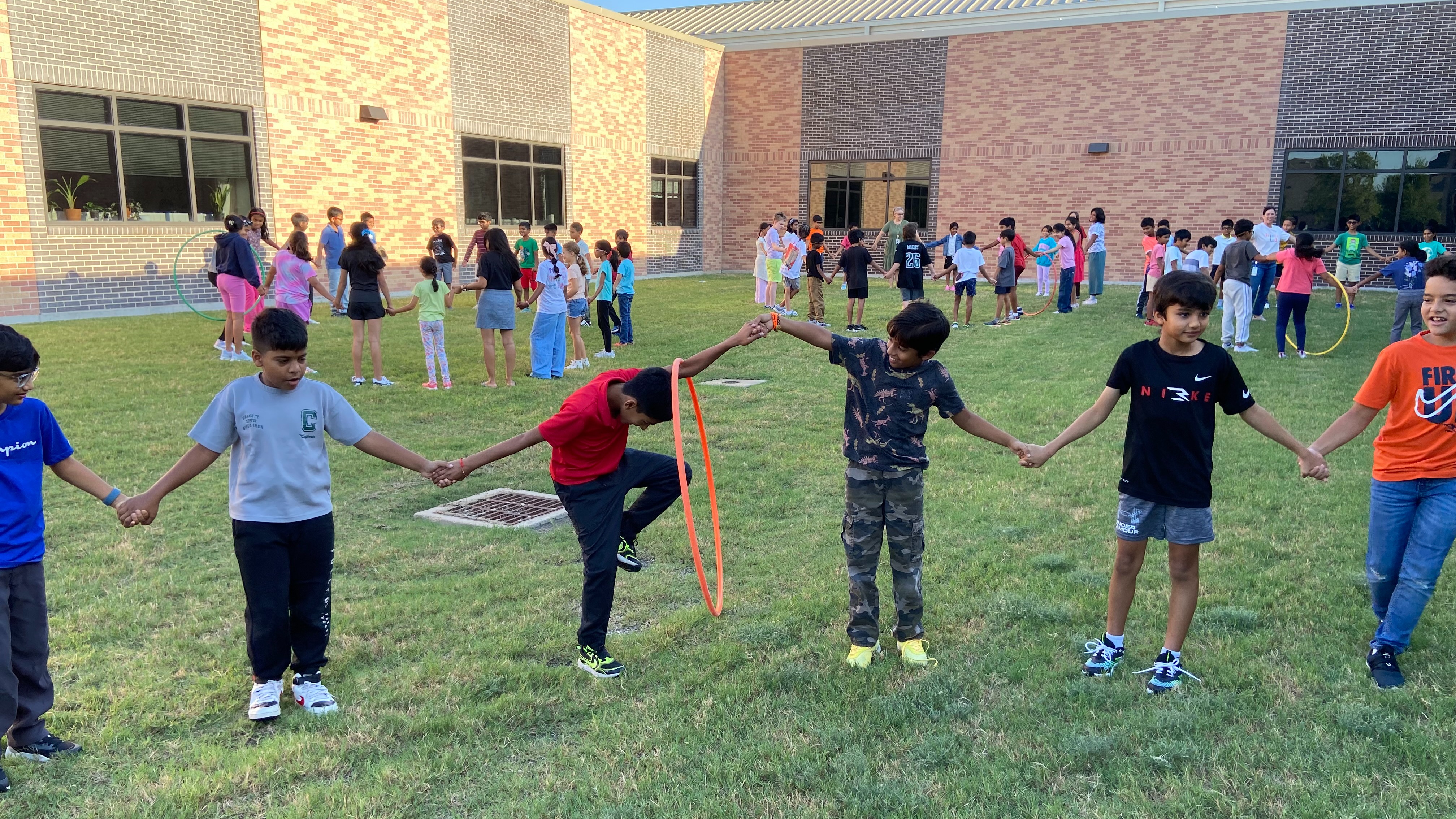 students passing a hula hoop in a circle