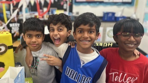 Four boys smiling at the camera.