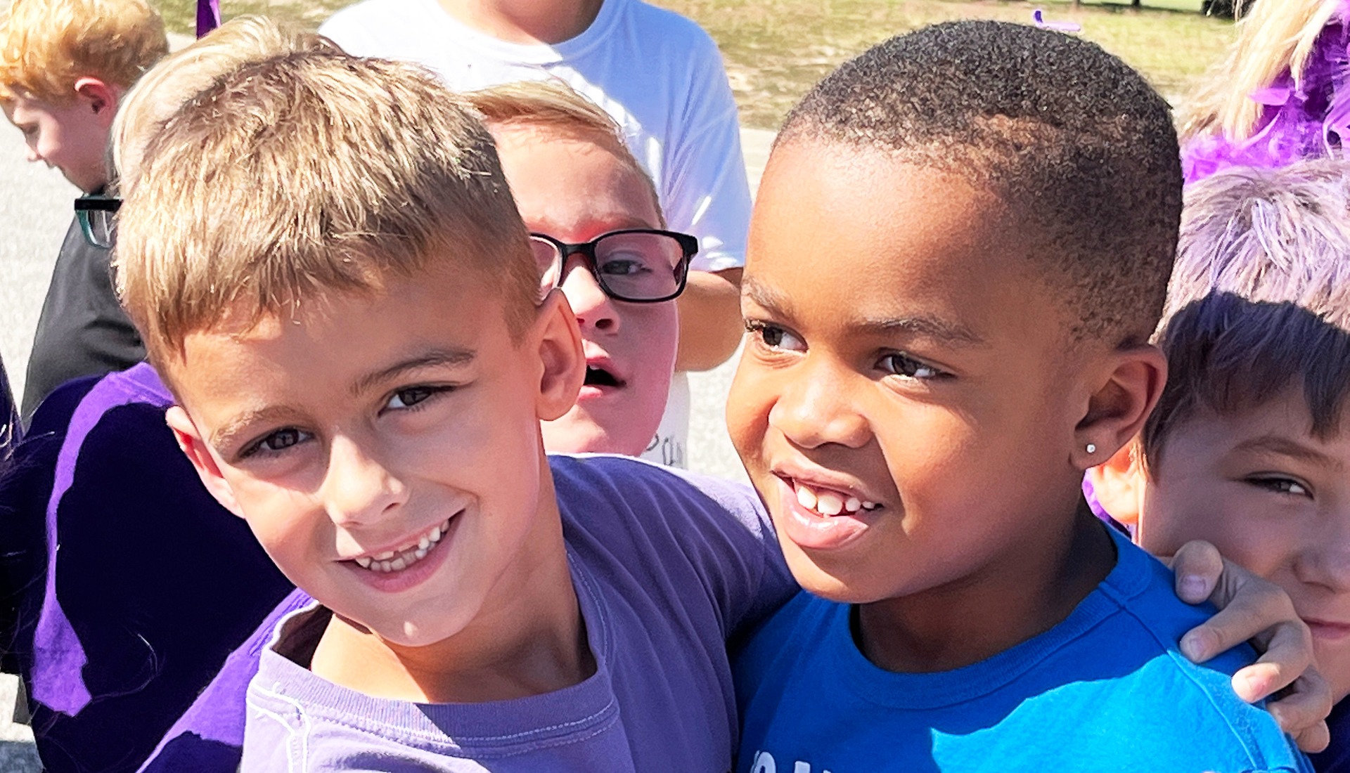 Two students hug at outdoor event