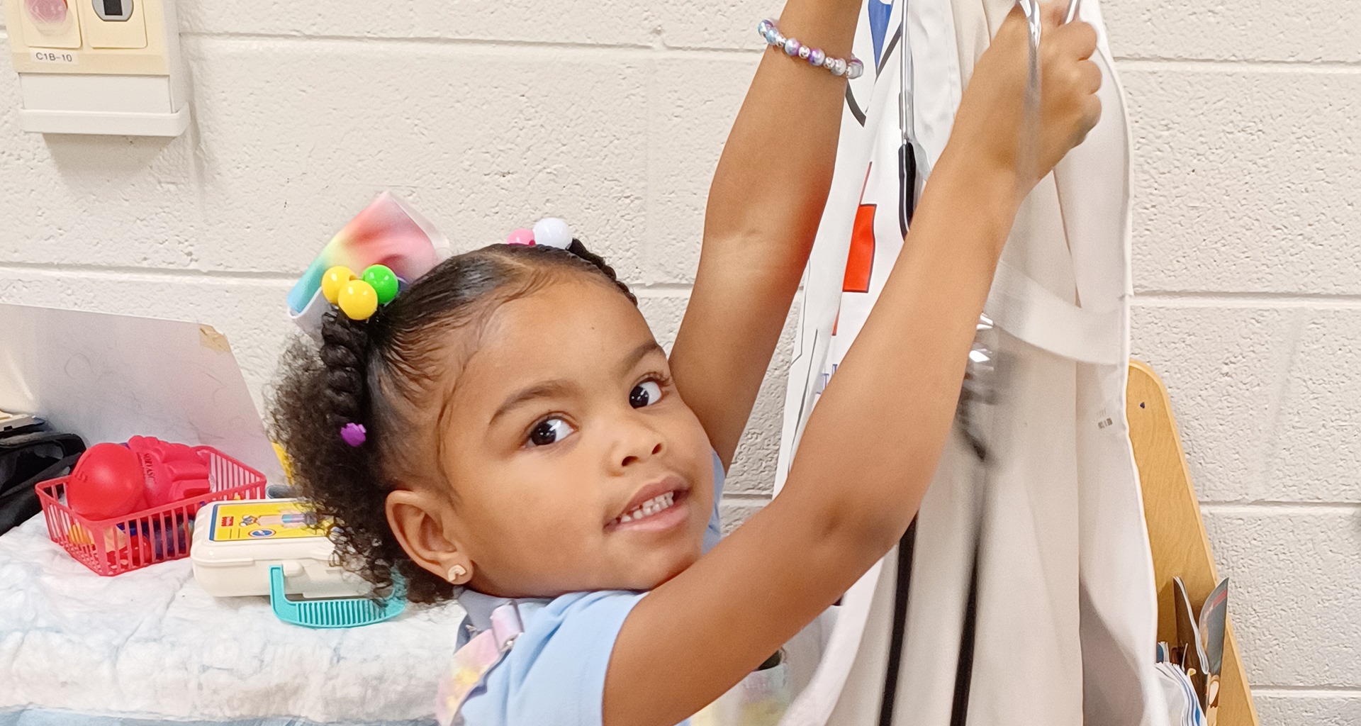 Young student grabbing her paint smock