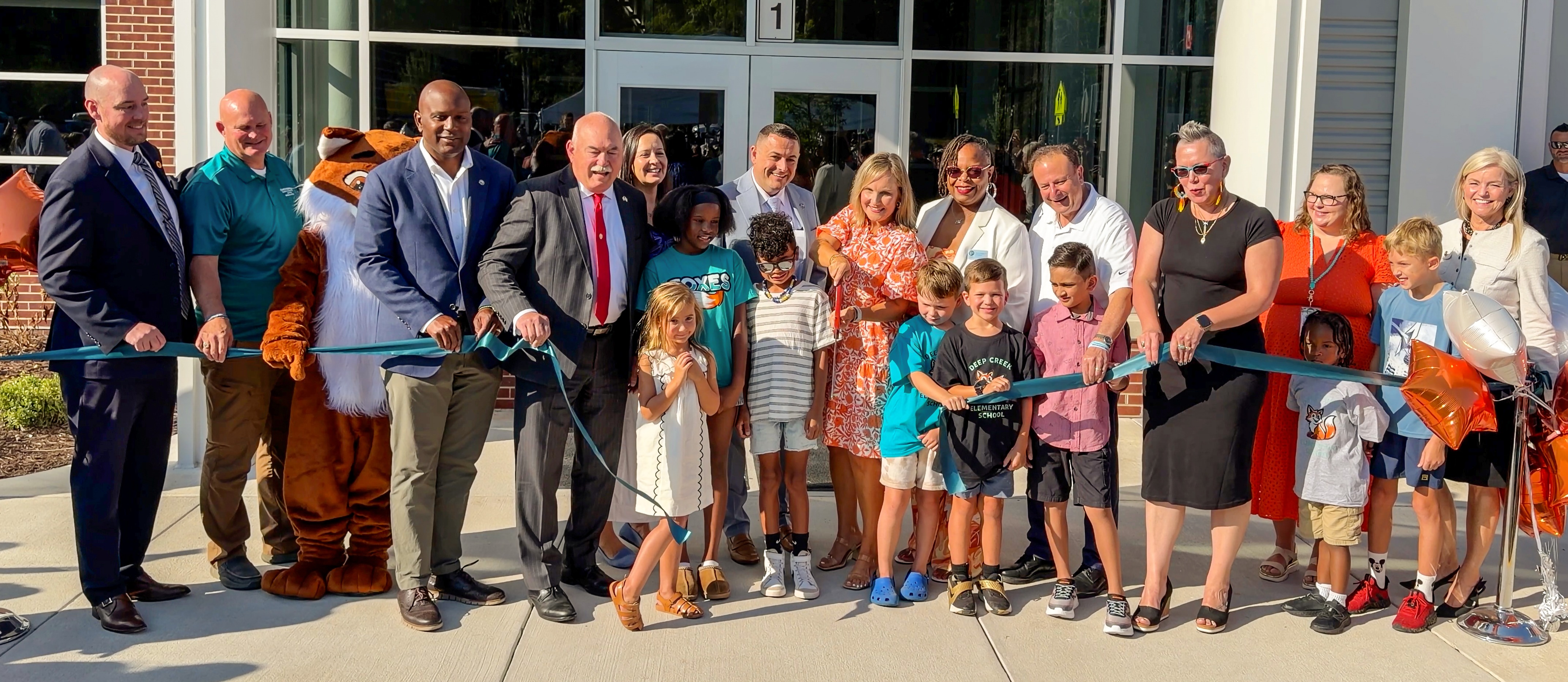 photo of school and county leaders cutting the ribbon to open Deep Creek Elementary