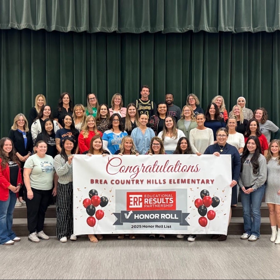Group photo of staff and teachers holding a banner 