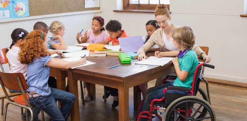 A group of small kids all sitting together in a table