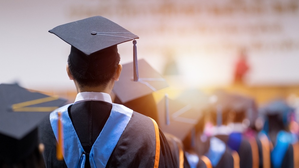 Graduate standing in front of stage