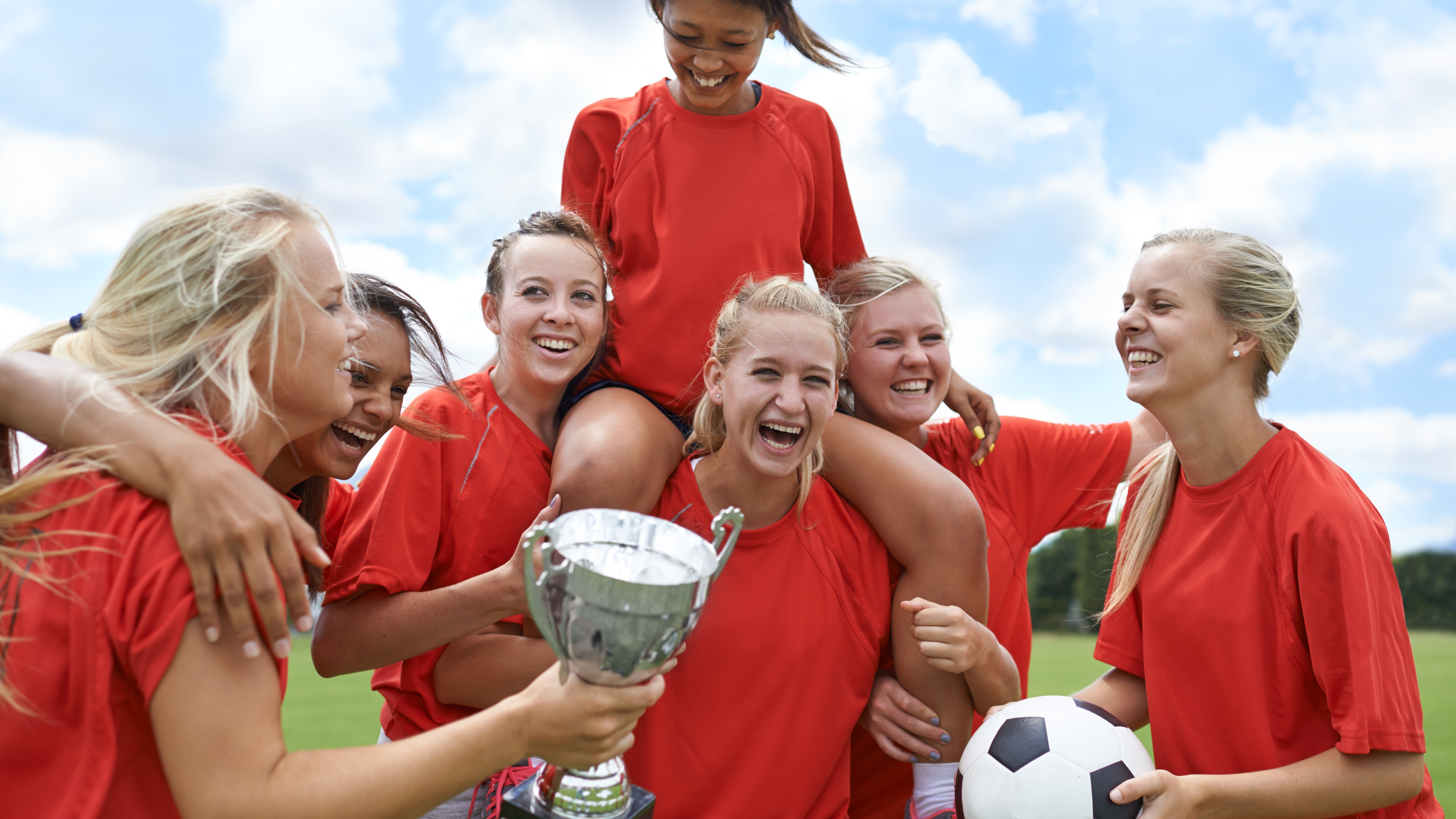 soccer players celebrating with trophy