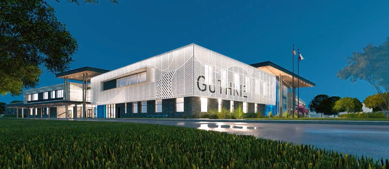 A modern, large building named "Guilford" is shown, surrounded by green grass and trees, with a flagpole in the background.
