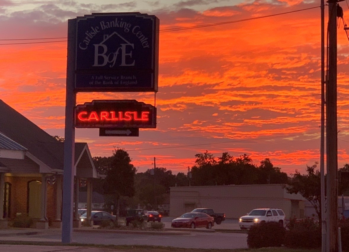 Sunset behind Carlisle's neon sign
