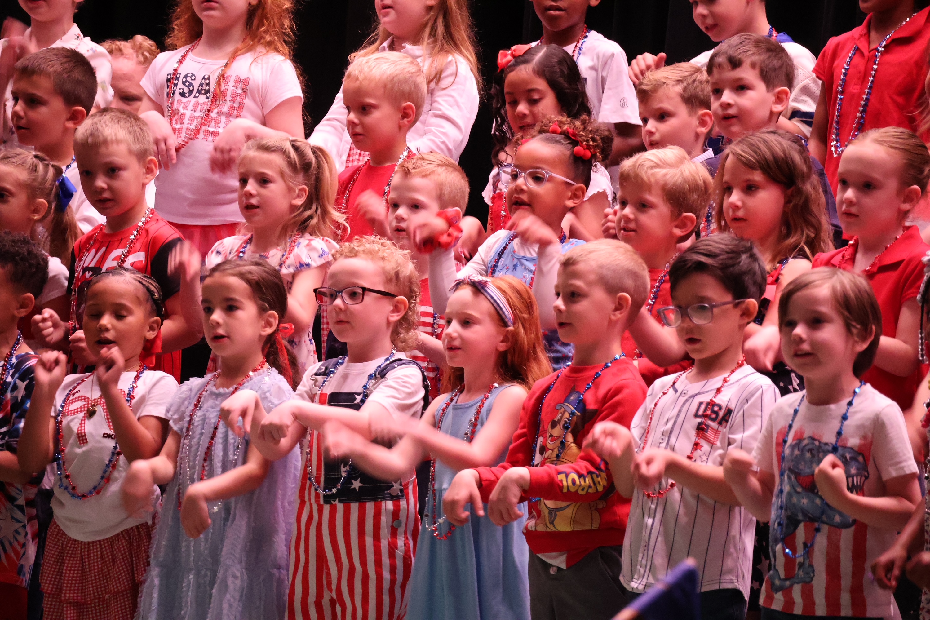 kindergarten students dressed in red white and blue and singing