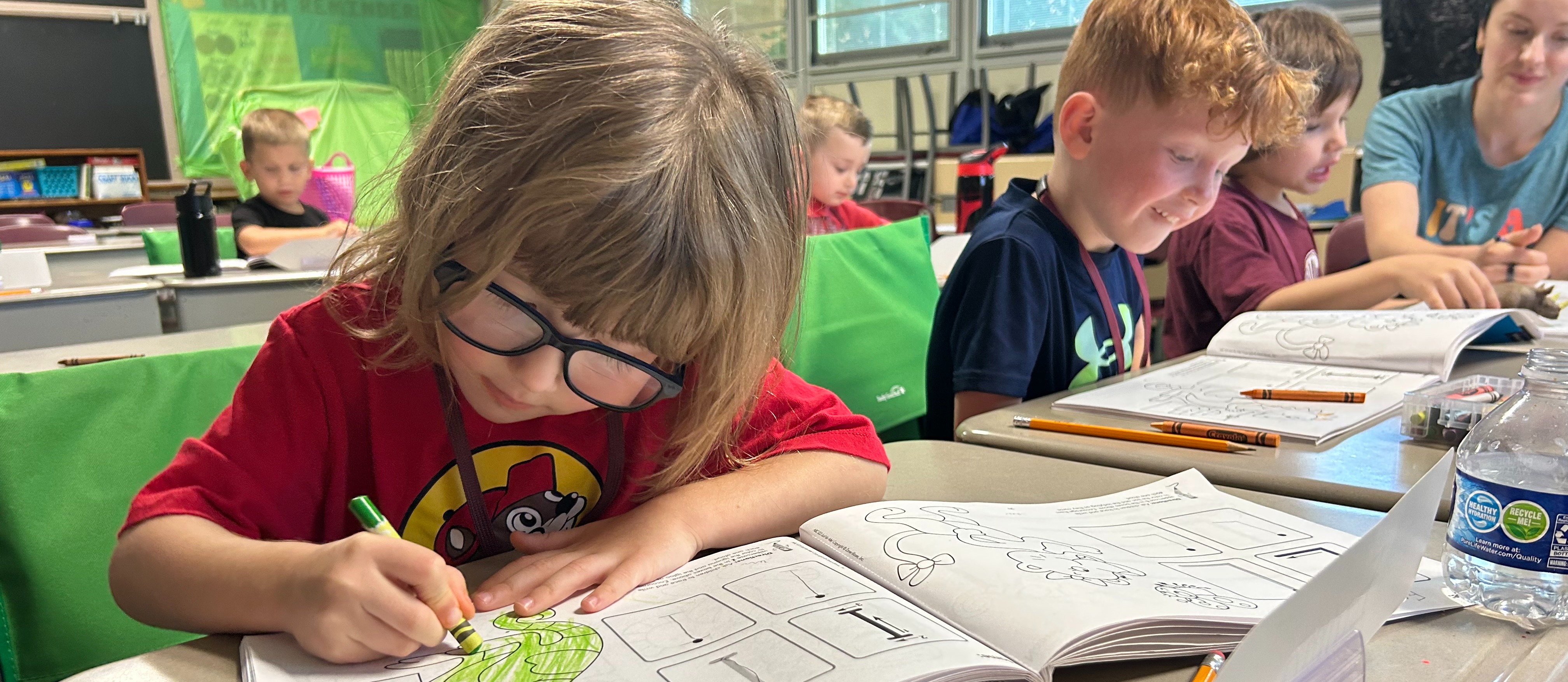 girl coloring in a row of students at Success by Six