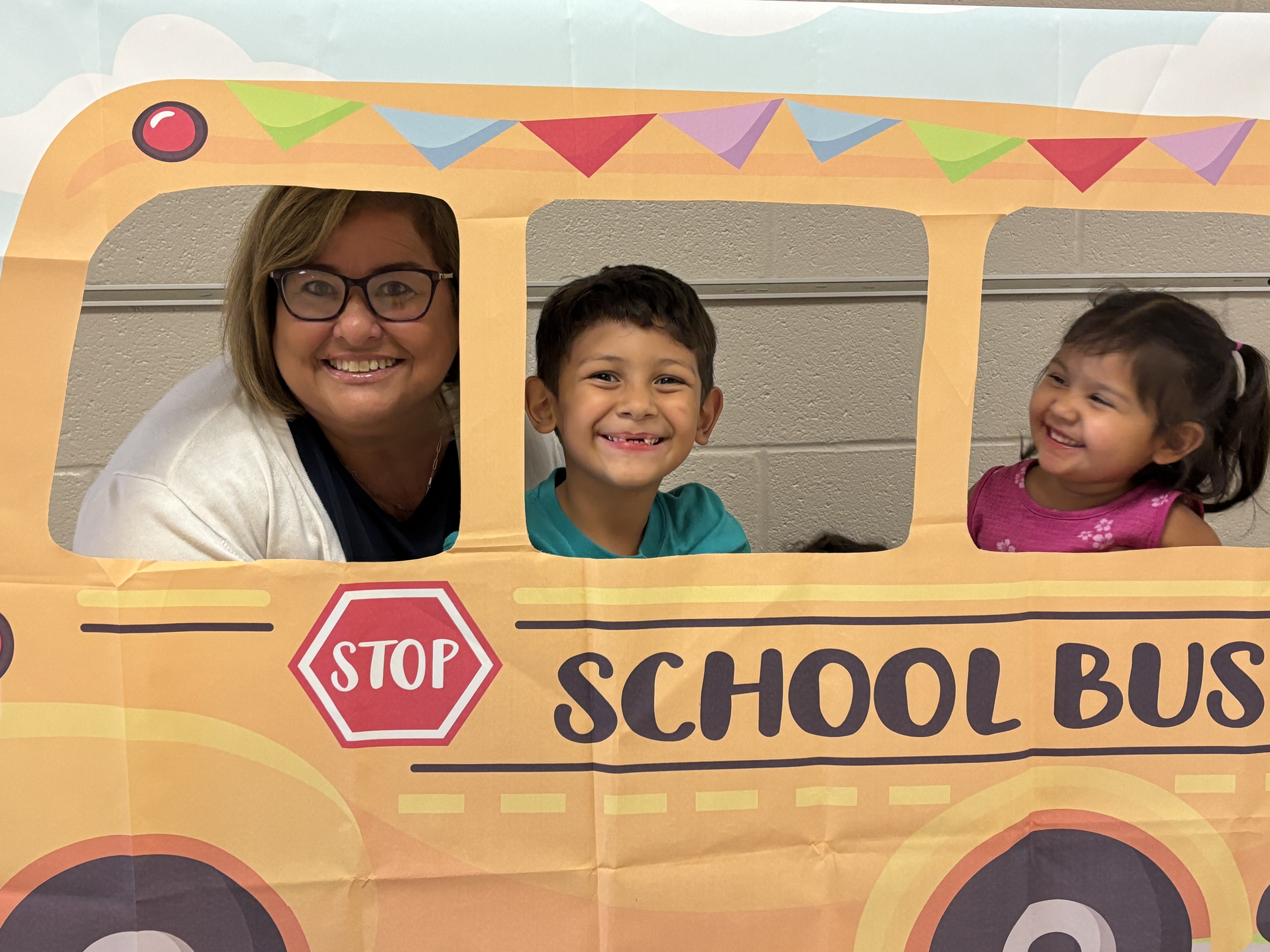 teacher and students in cut out cardboard school bus