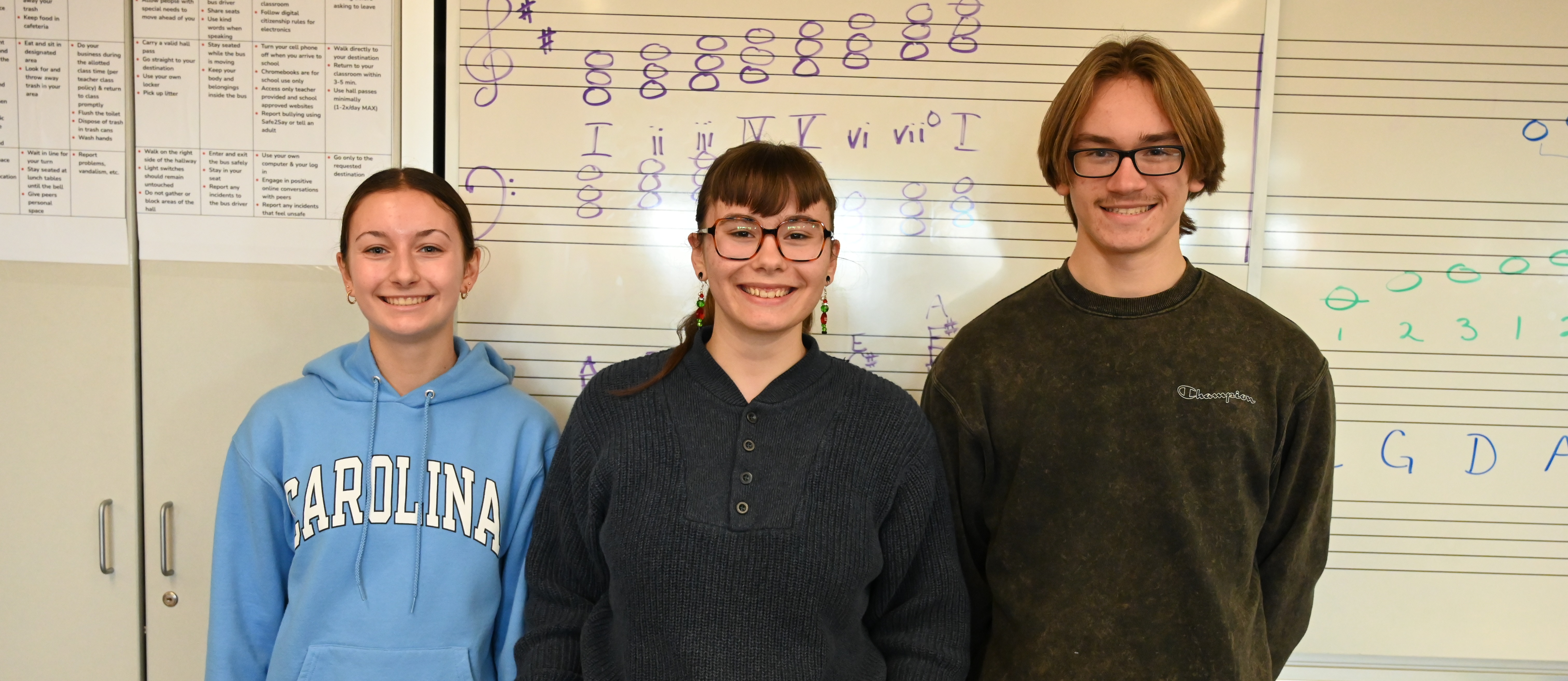 Three students stand together in music class