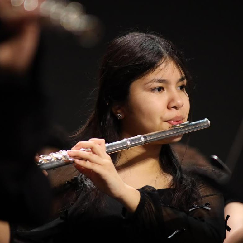 Female student playing flute in concert setting