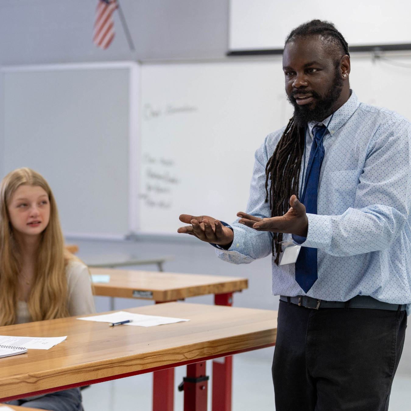 Black male teacher with locs teaches class