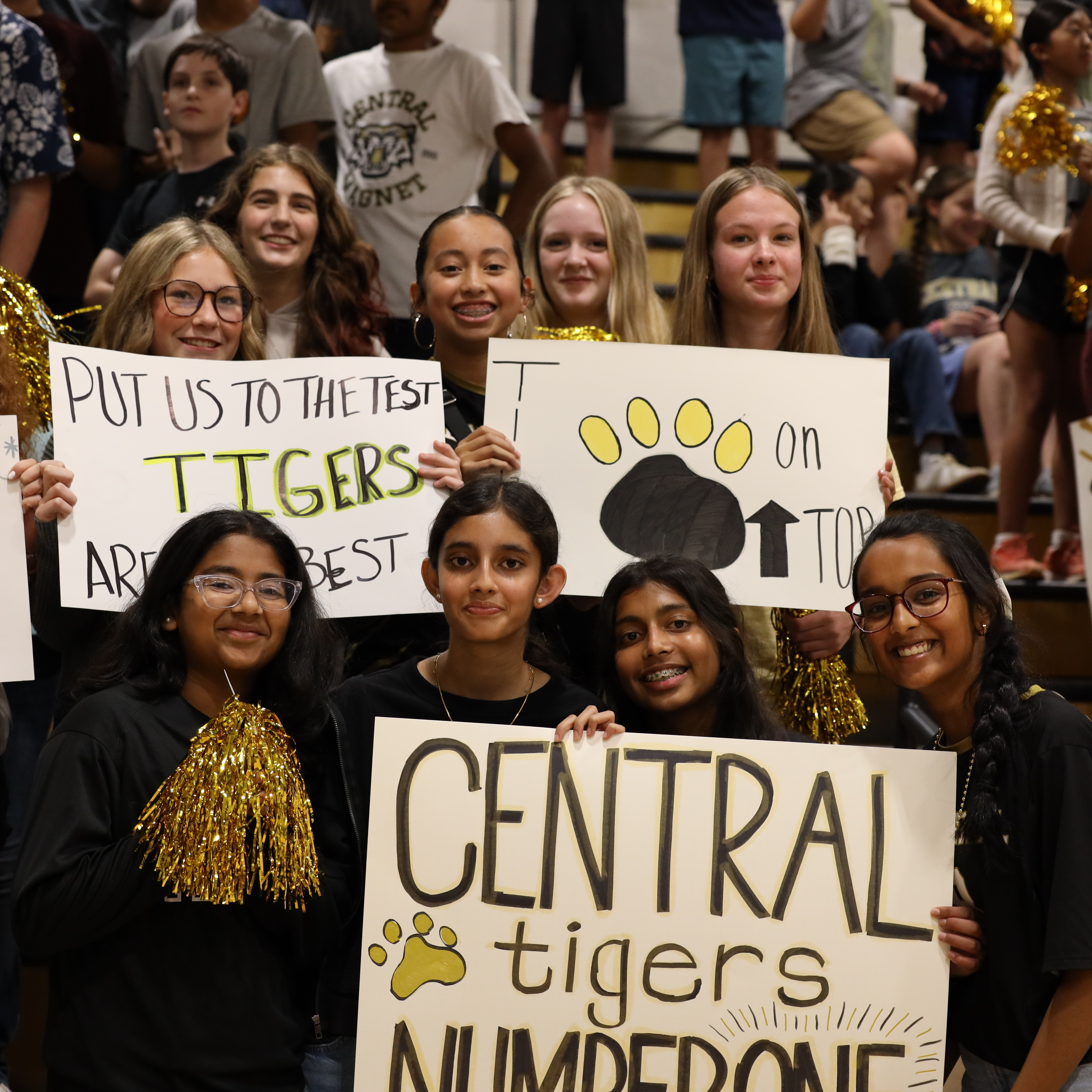 Students hold posters and pompoms in school gym