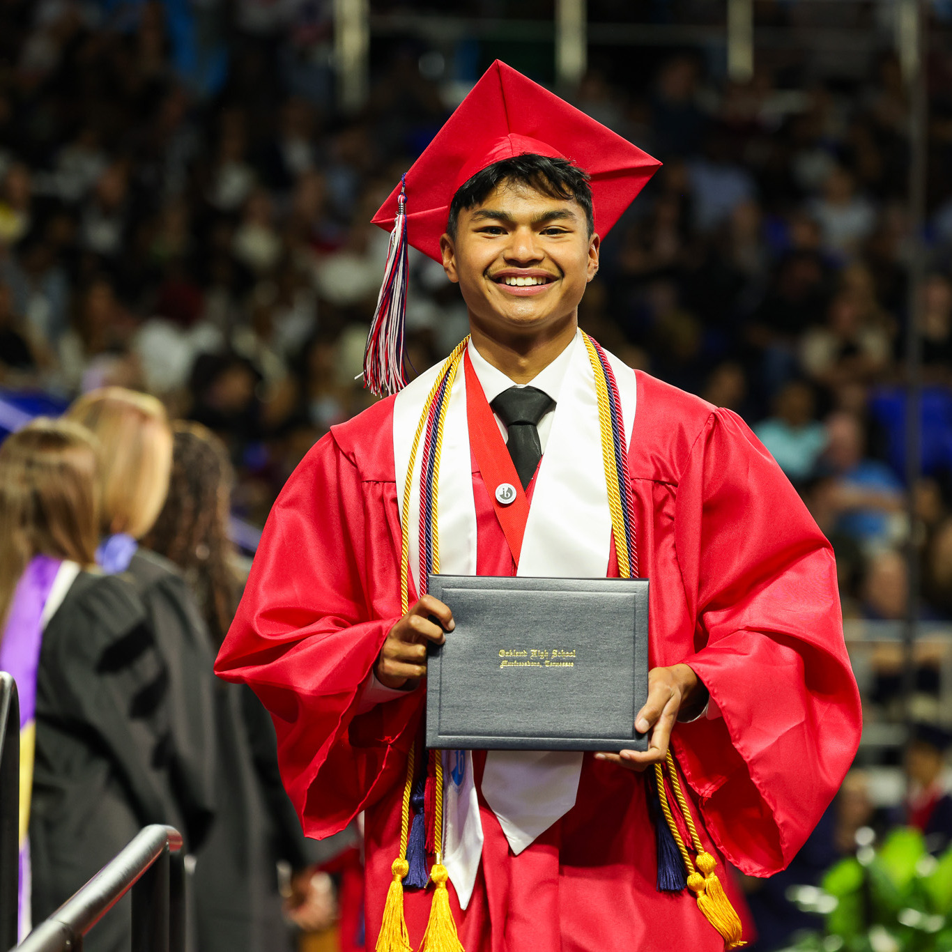 High school male in red graduation gown