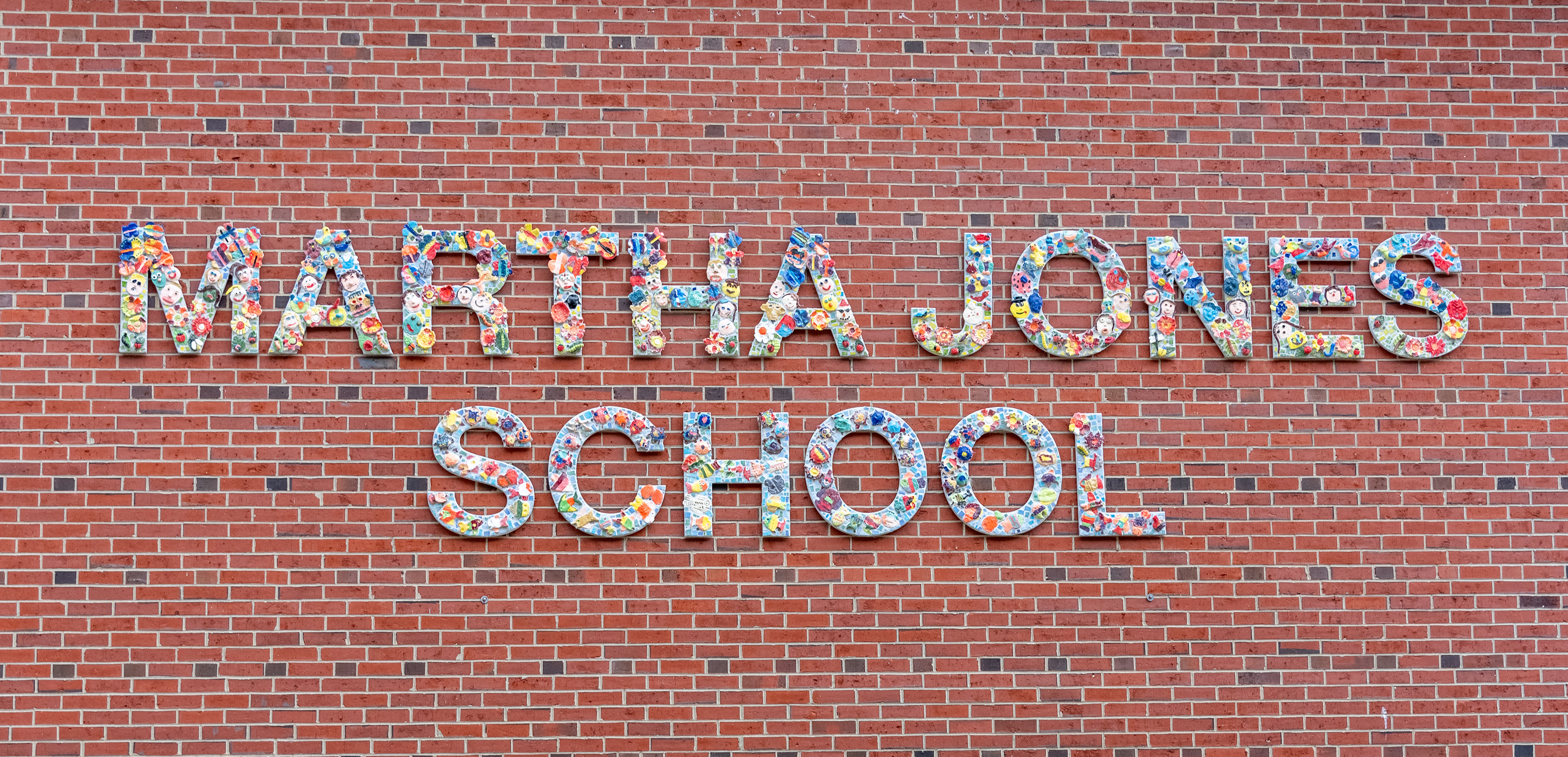 Sign of Martha Jones School on brick wall