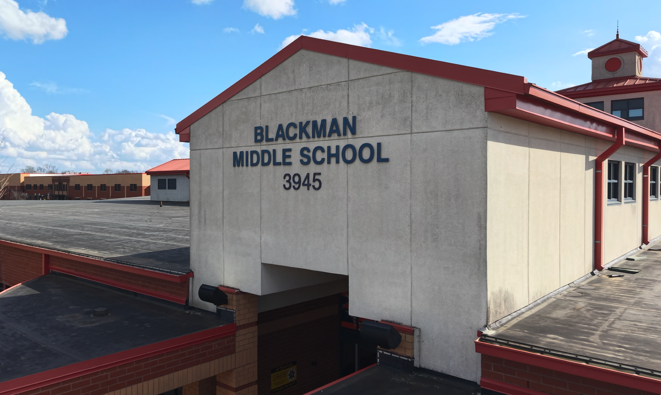 A white building with red trim. "Blackman Middle School 3945" is written in blue on the side.