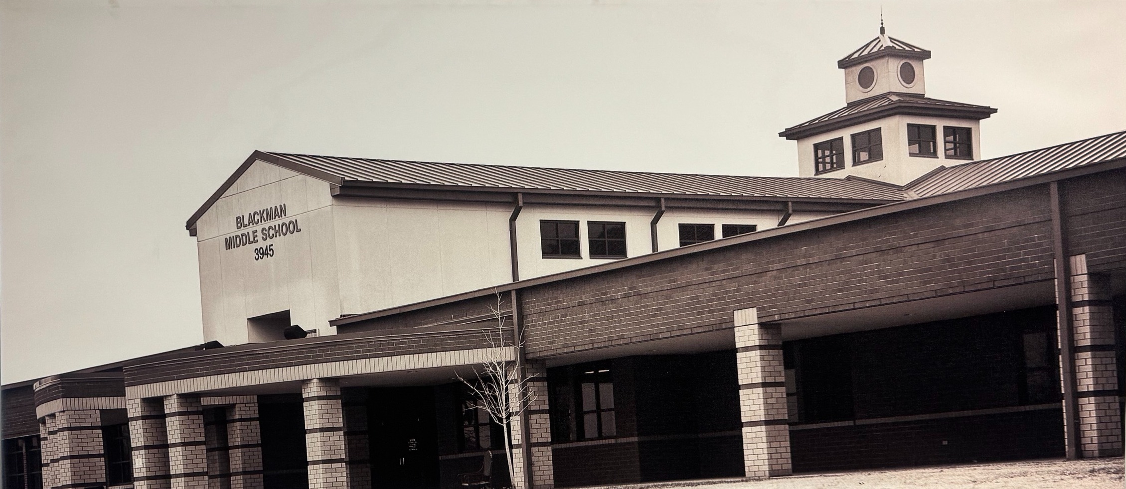 Black and white photo of a school building with the text Blackman Middle School 3945 displayed on the side
