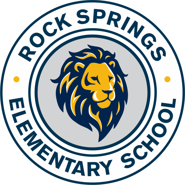 A circular logo features a lion's head in blue and yellow against a gray background. "ROCK SPRINGS ELEMENTARY SCHOOL" is written in a curved style around the lion.