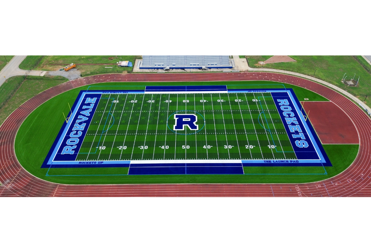 Aerial view of a football field with blue, green, and red sections. Letters "ROCKVALE ROCKETS" on field.