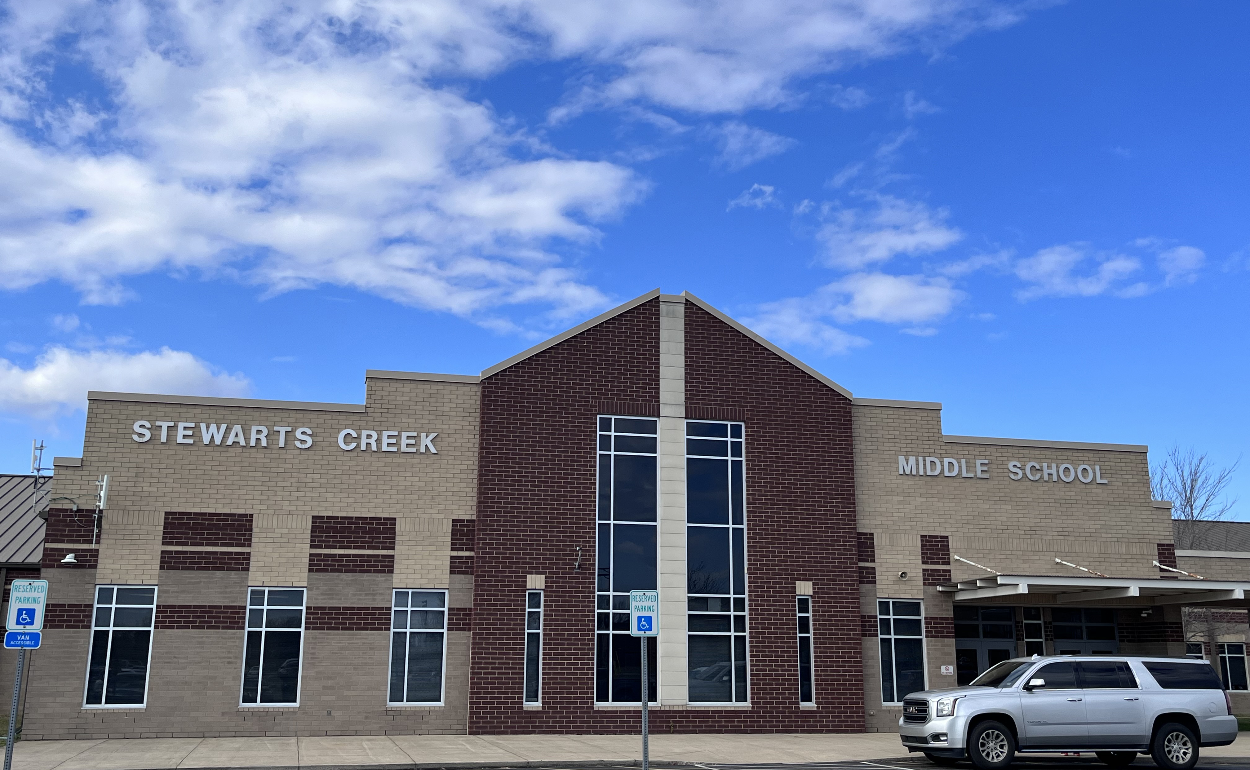 Beige brick building with Stewarts Creek Middle School in gray letters