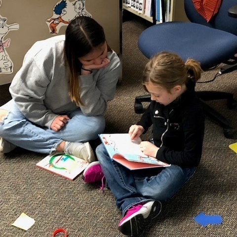 child sitting down with student reading