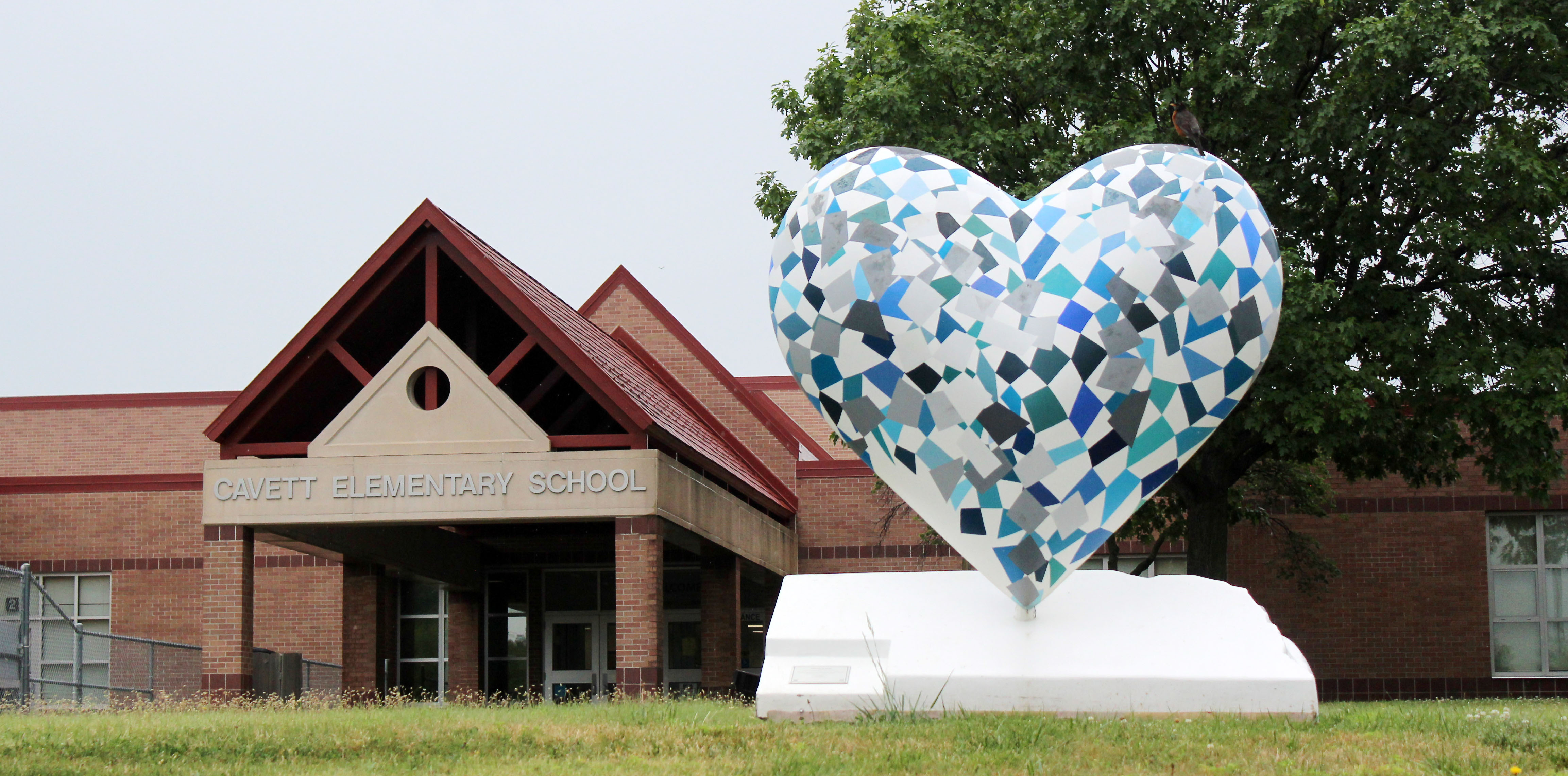 Front entrance of Cavett Elementary with a glass heart in the foreground