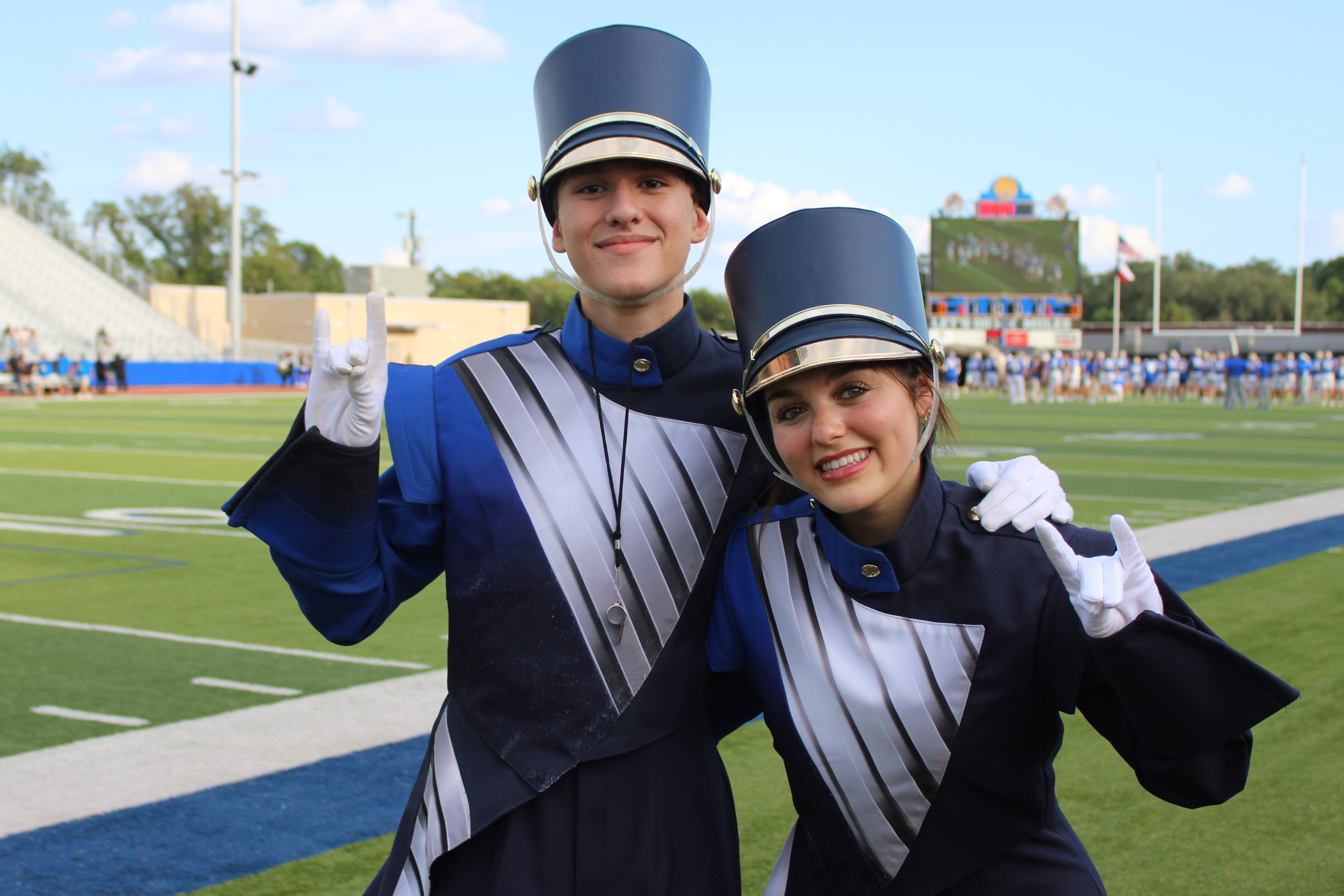 Two drum majors pose on football field