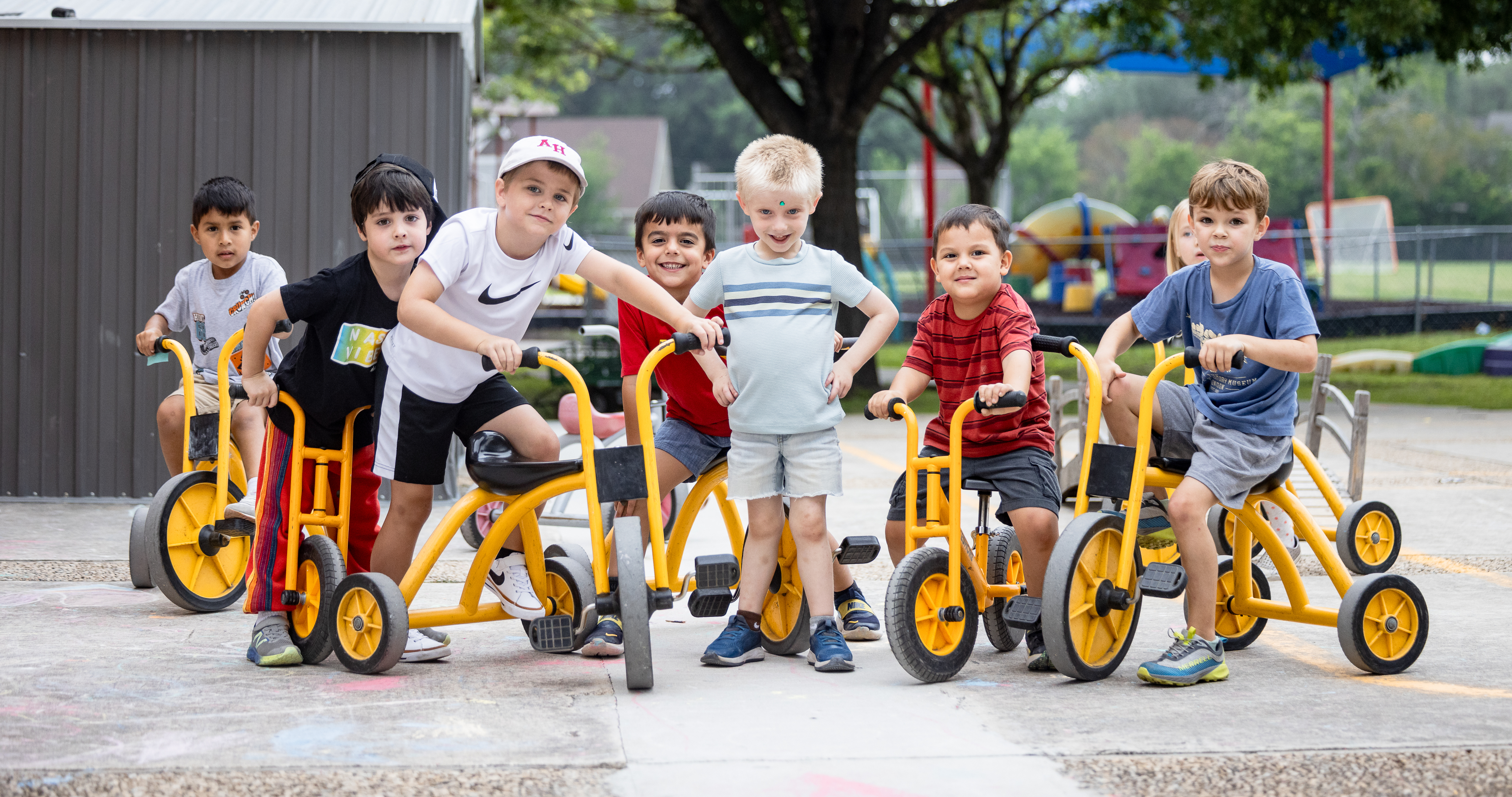 Group of young students on tricycles