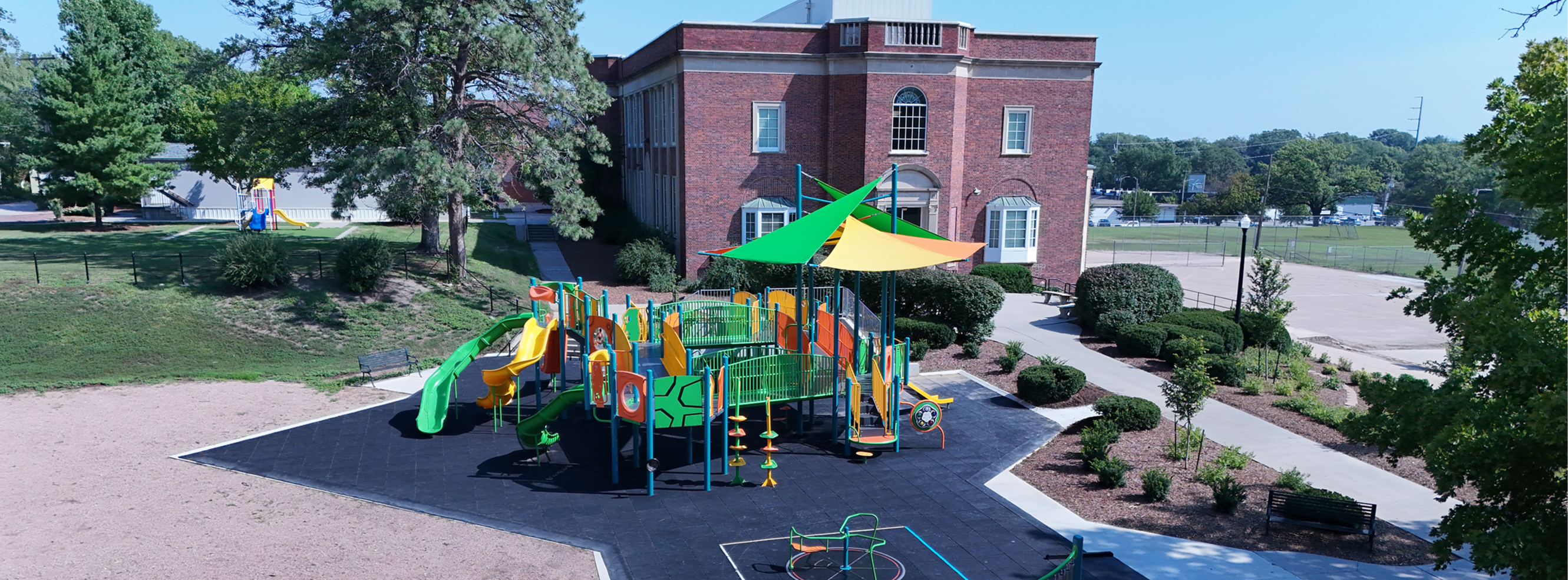 Wide view of Sheridan Elementary with playground equipment in the foreground