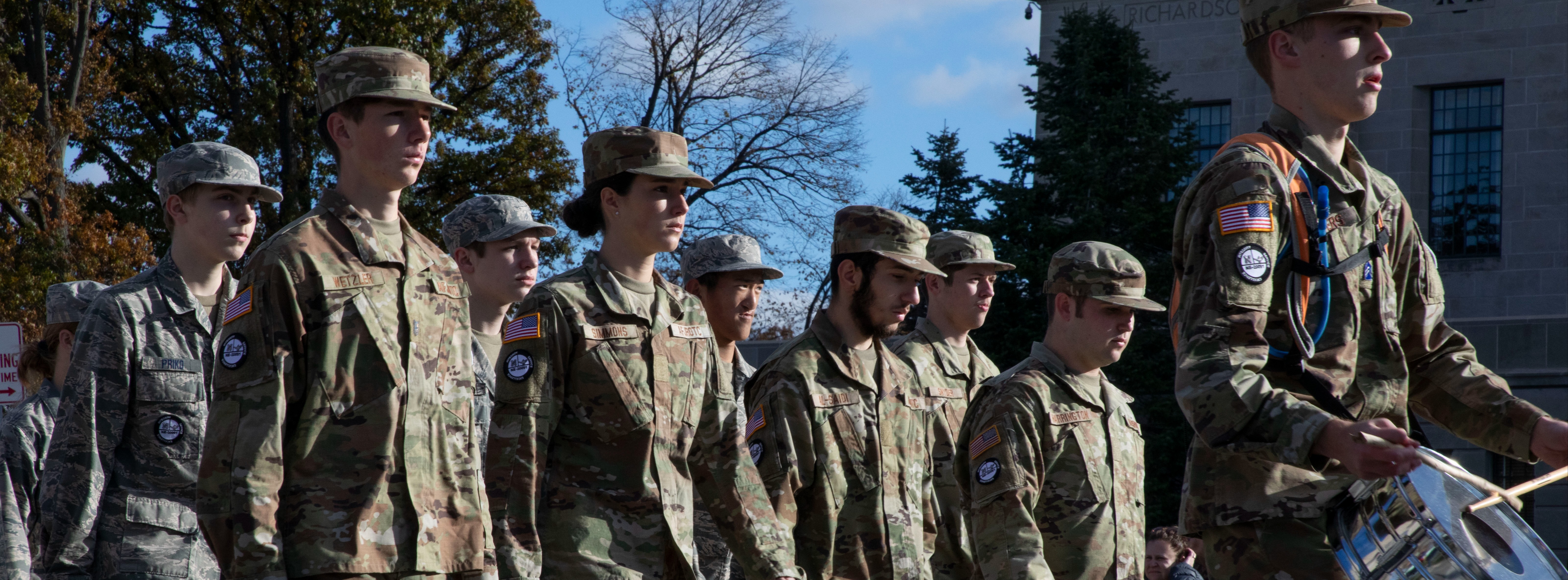 AFJROTC students marching in uniform with a drummer in front