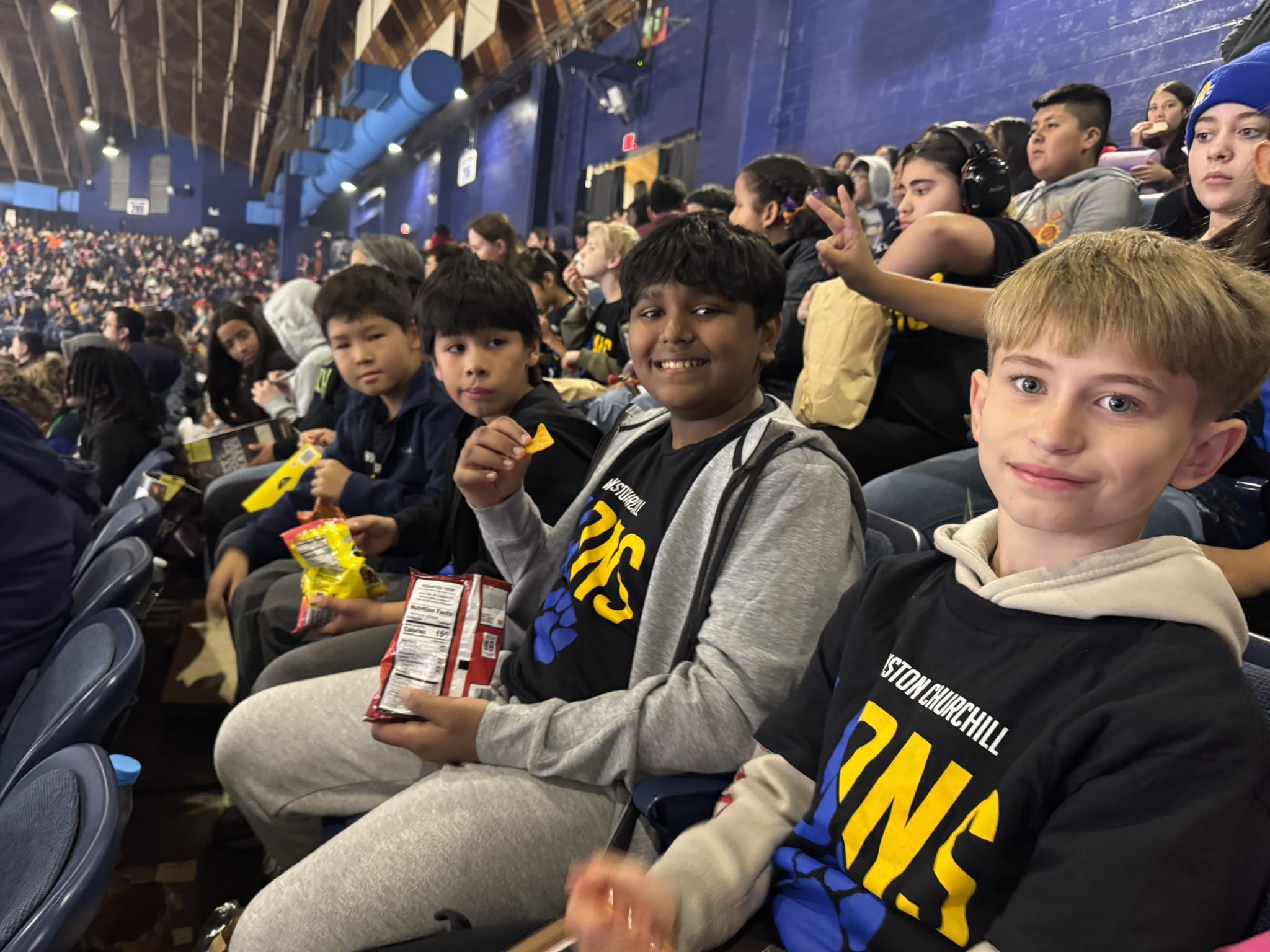 A group of students sitting in the stands at a Chicago Wolves hockey game.