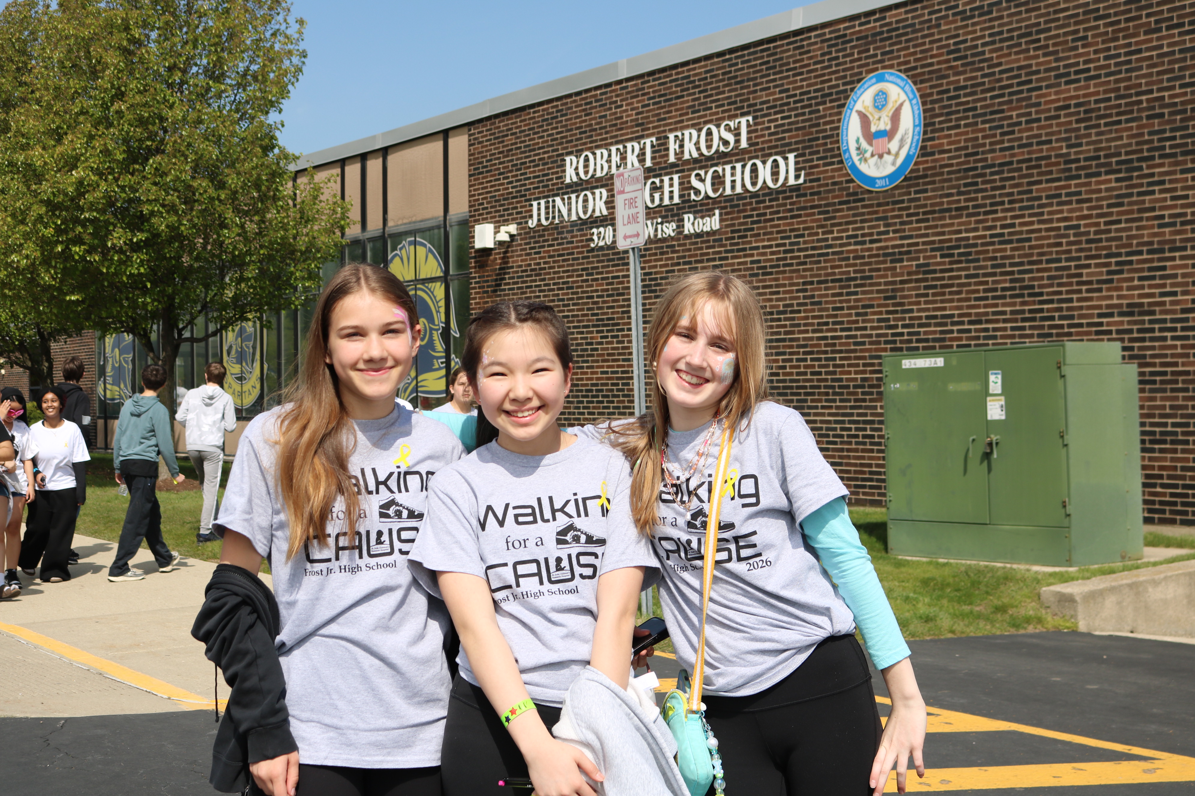 three girls standing in front of school