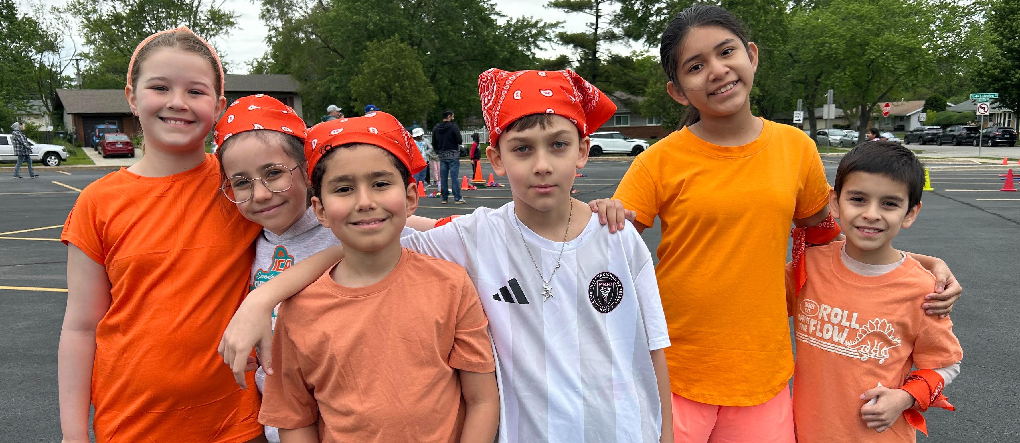 Students wearing orange clothing and accessories for their field day team