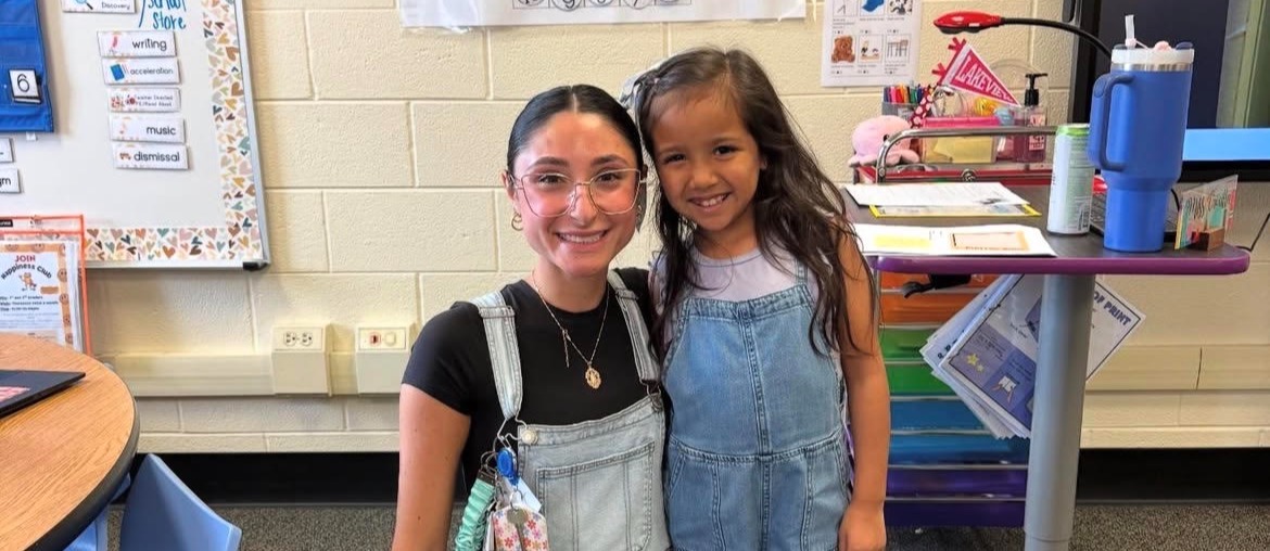 Teacher and student  next to each other in a classroom
