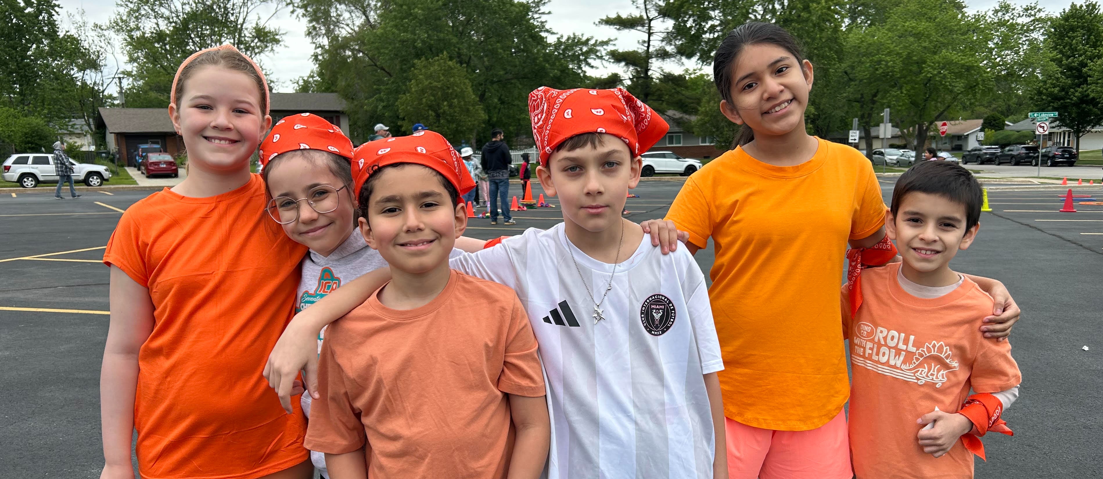 Students wearing orange clothing and accessories for their field day team