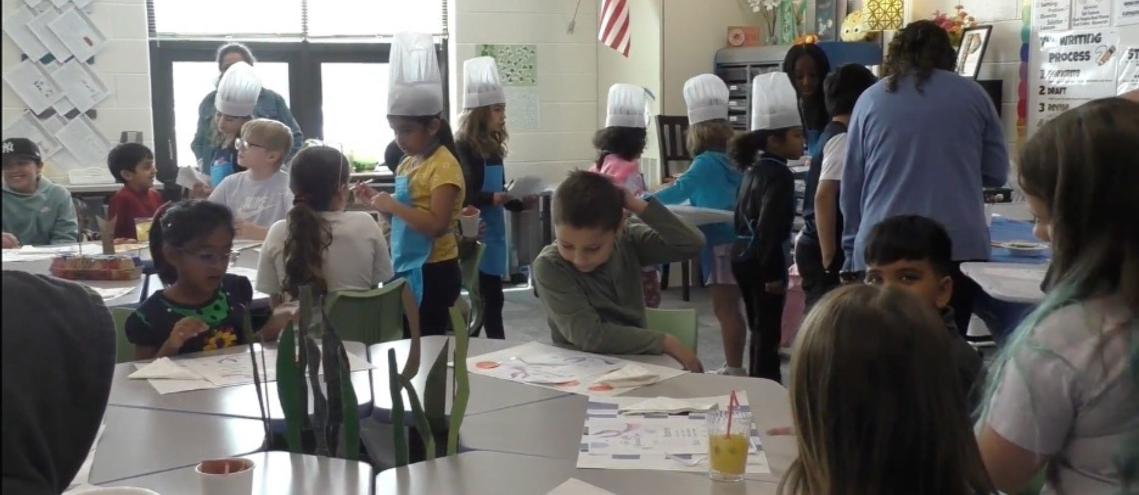 Students in classroom sitting at desks during a restaurant simulation